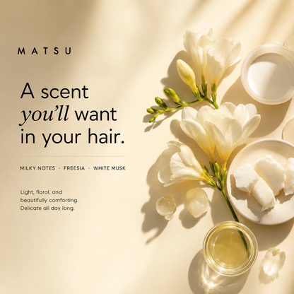 A clean, professionally styled product advertisement for MATSU hair care. The image features a warm cream background with soft diagonal shadows, white carnation flowers, and various cosmetic containers including a jar of white cream, a glass of golden liquid, and a small dish of solid cream.