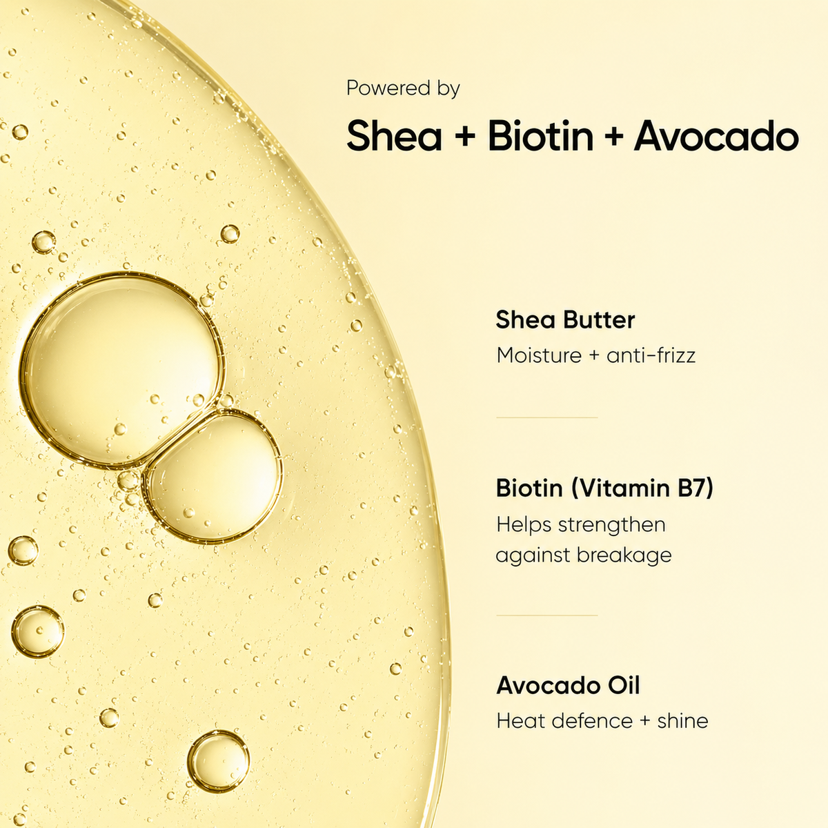 A close-up of a golden yellow shea butter oil with visible air bubbles on a cream background, with text reading 'Powered by Shea + Biotin + Avocado' and ingredient callouts for Shea Butter, Biotin (Vitamin B7), and Avocado Oil.